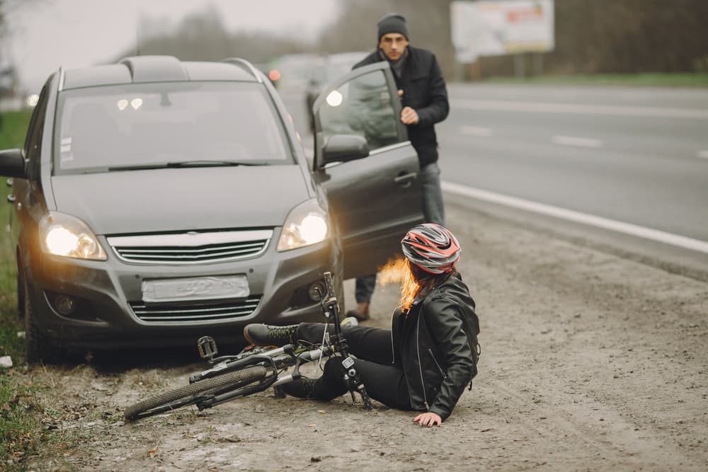 Collision aftermath: Woman in a helmet involved in a car crash.