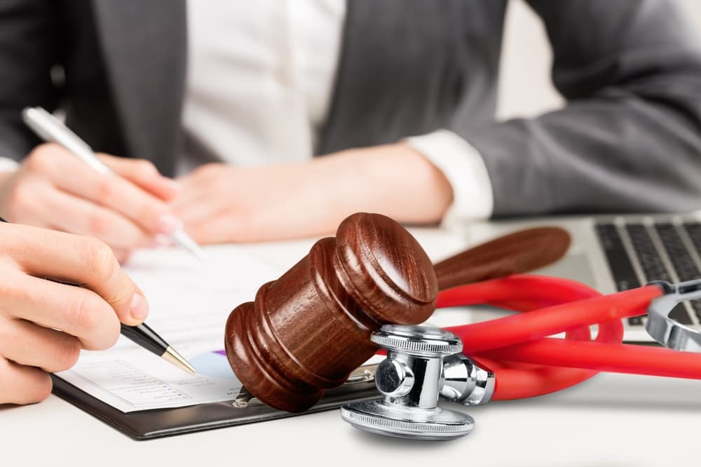 Physician taking notes with a stethoscope on the desk, illustrating medical documentation and healthcare professionalism.